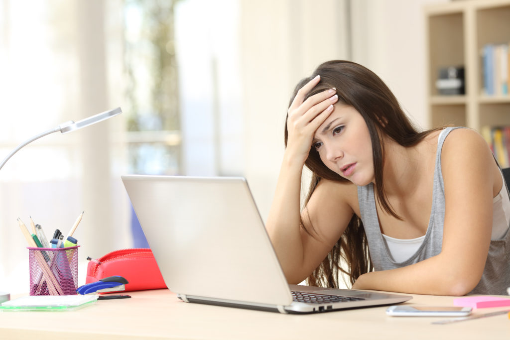 girl looking on computer frustrated because she can't find any information on outside scholarships